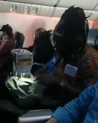 Watch video of a  woman sewing clothes  inside an aeroplane.