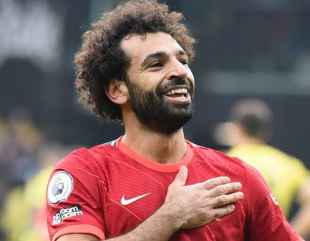 Salah poses with commemorative Liverpool shirt alongside teammates after scoring 200 goals for the club