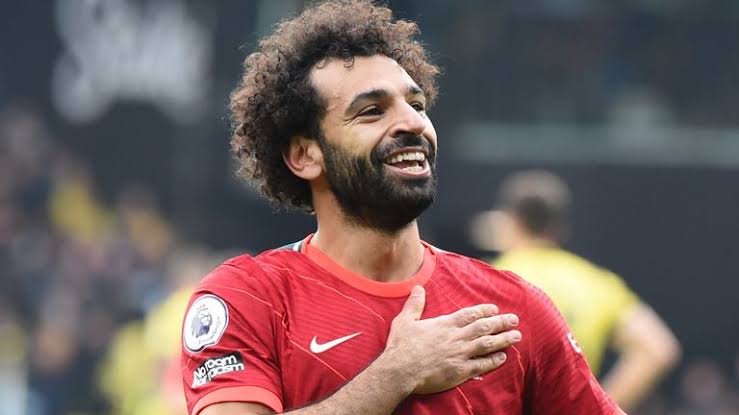 Salah poses with commemorative Liverpool shirt alongside teammates after scoring 200 goals for the club